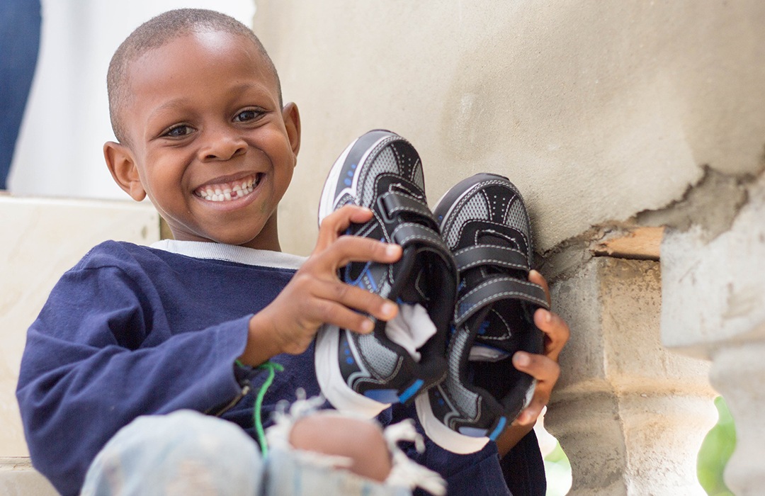 Child holding a pair of new shoes 